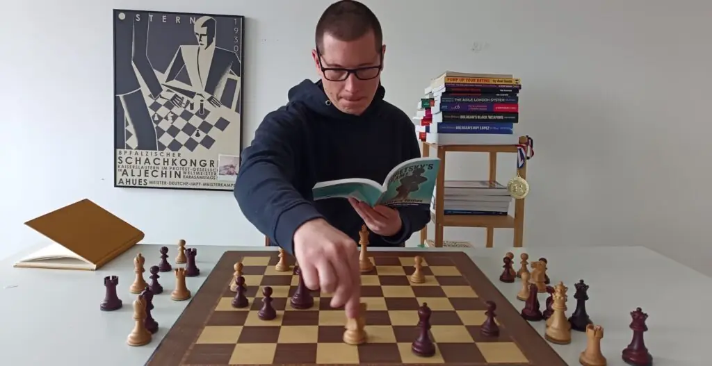 Chessreads, how to read chess books, author moving chess piece while holding a book
